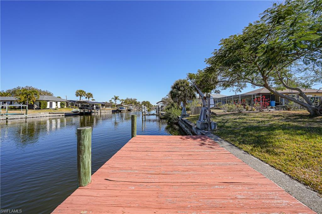 Waterfront canal access with a private red-stained wooden dock