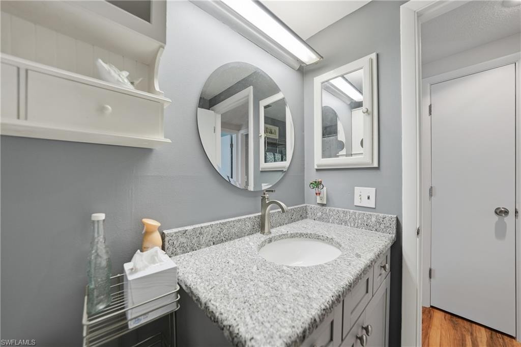 Guest Bath: Granite countertop with an undermount sink, brushed nickel faucet, and shaker-style cabinetry