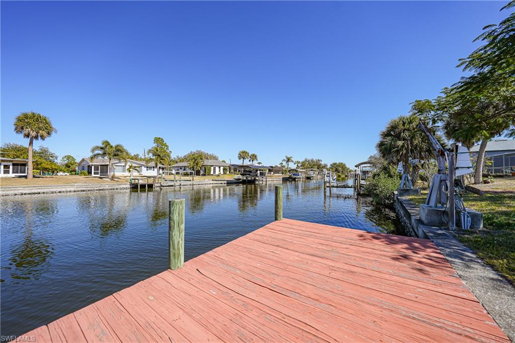 Canal-front property featuring a wooden dock and concrete seawall