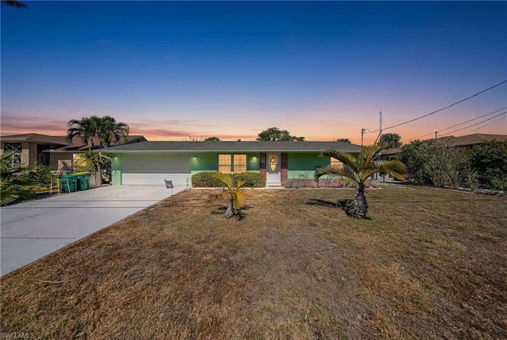 Single-story residence featuring a painted exterior, attached two-car garage, and a concrete driveway