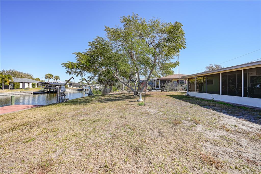 Waterfront property featuring a canal, private dock and screened-in porch