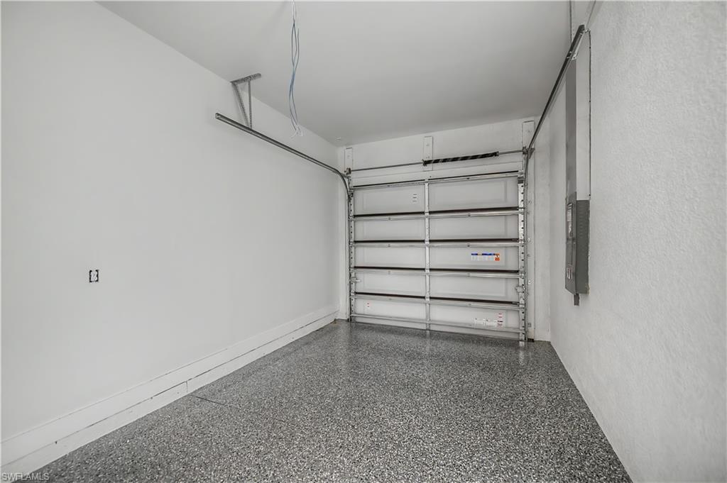 Garage featuring a sectional overhead door and speckled epoxy flooring