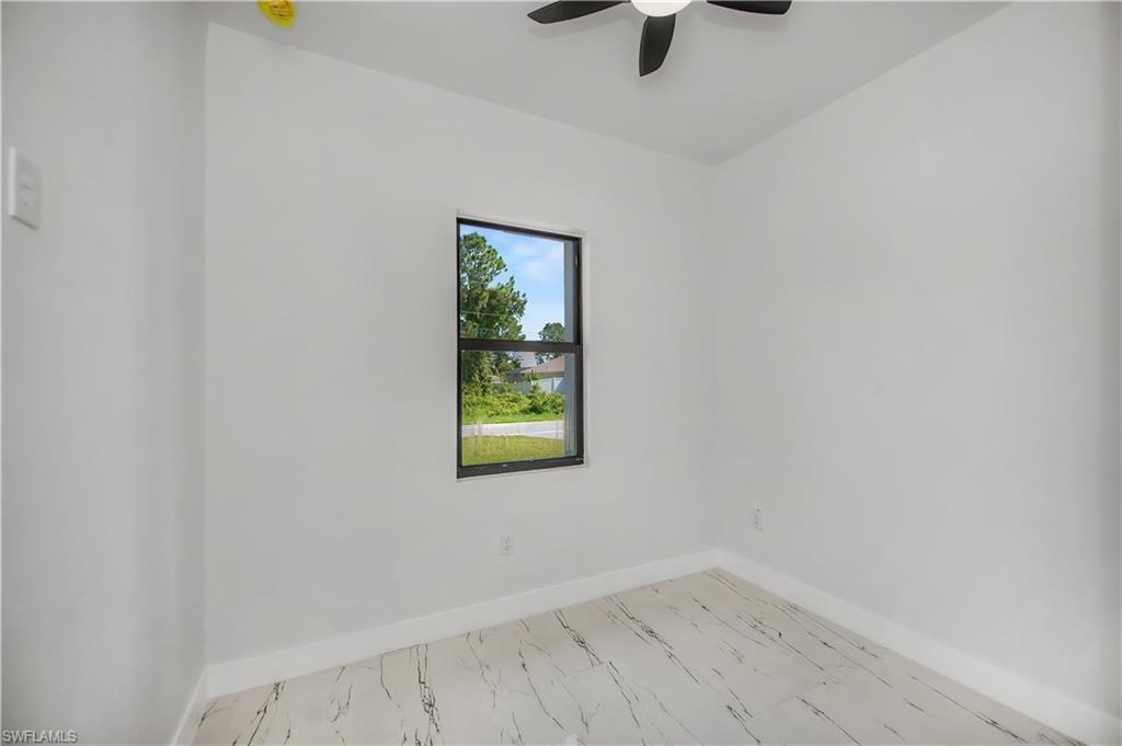 Recessed window with black framing and white sills, ceiling fan with black blades, and white tile flooring