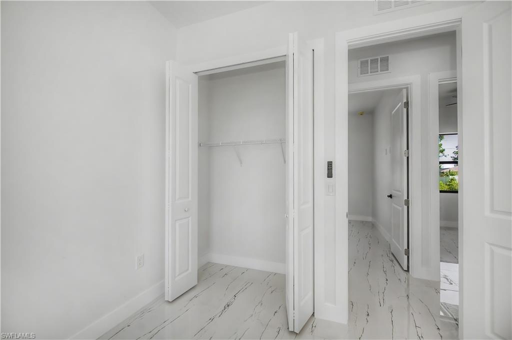 White walls with bi-fold closet doors, white wire shelving, and white baseboard trim