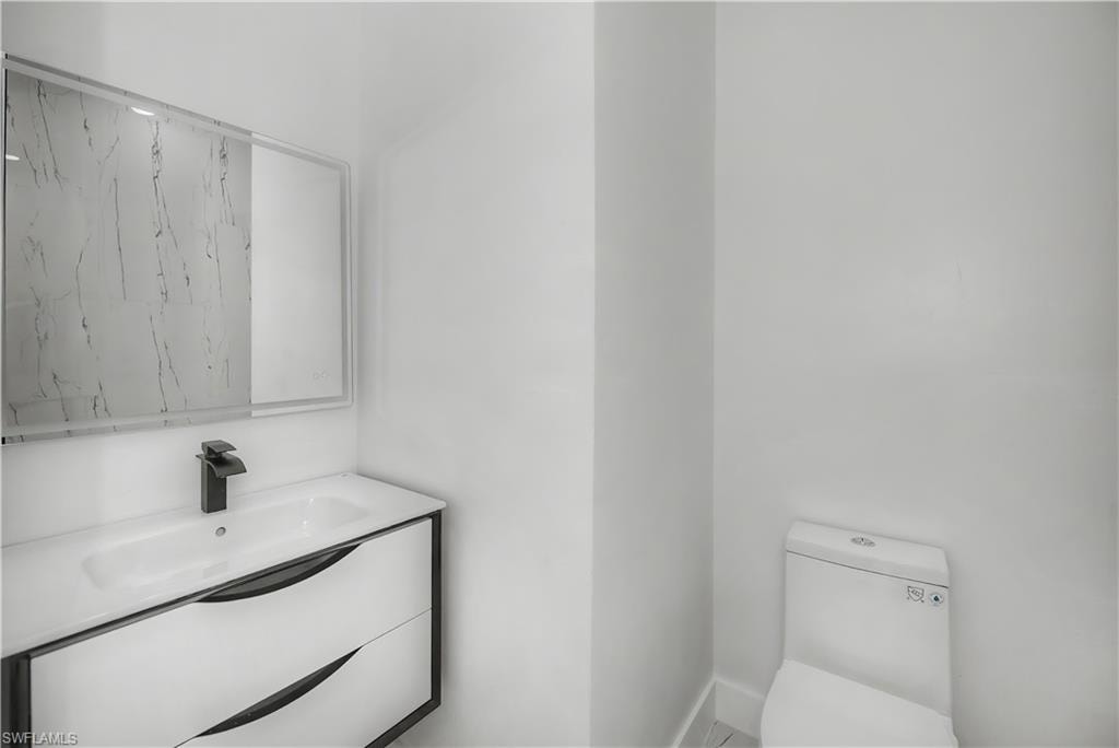Floating vanity with integrated sink, black-finish faucet, and framed mirror