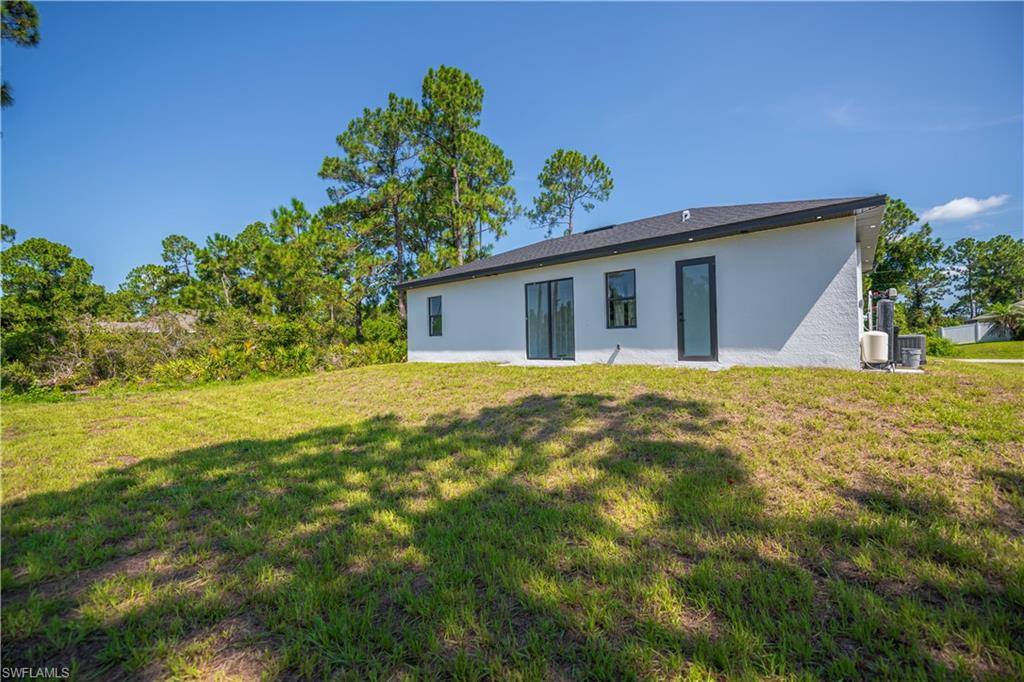 White stucco exterior with a black-shingled roof and black-framed windows
