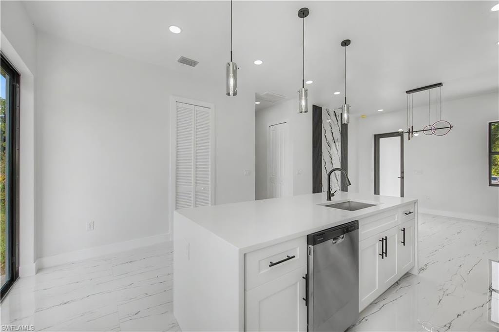 Kitchen island featuring a white countertop, under-mount sink with a matte black faucet, and stainless steel dishwasher