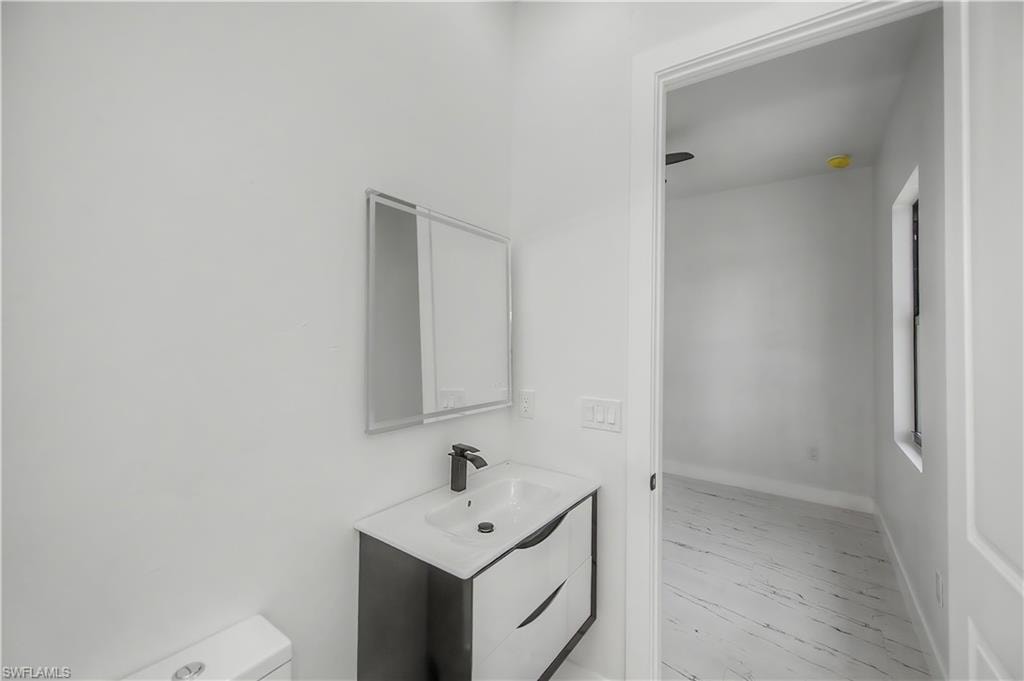 Vanity with black base cabinetry, white countertop, and black faucet