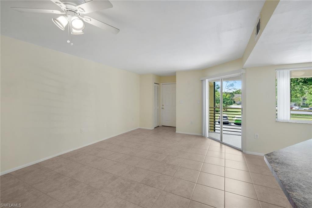 Spare room featuring light tile patterned flooring, ceiling fan, baseboards, and visible vents