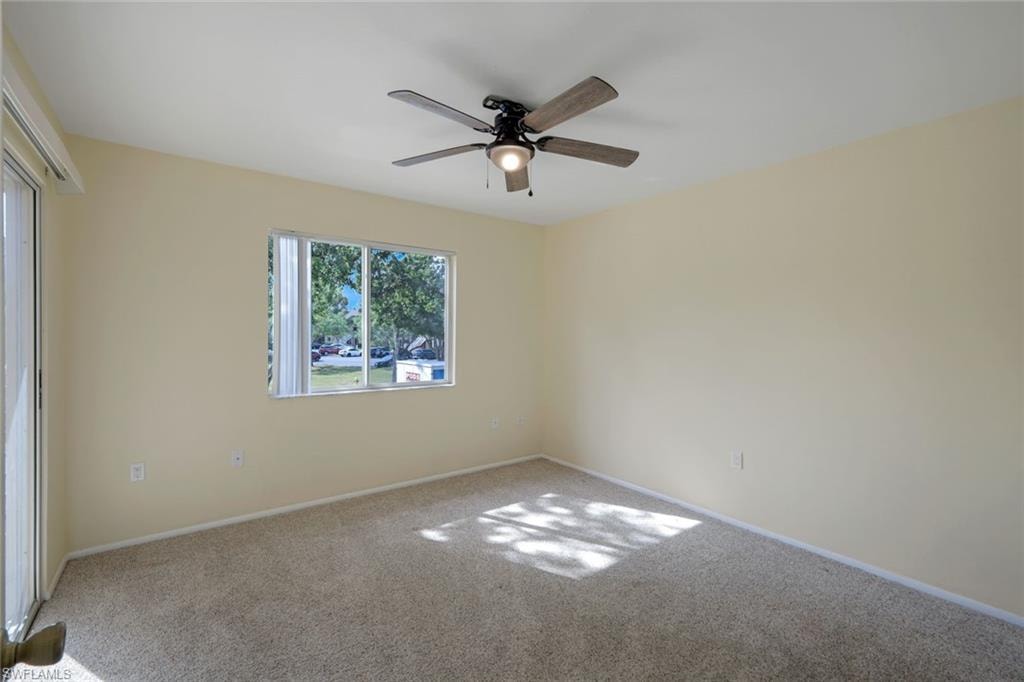 Spare room featuring ceiling fan, carpet flooring, and baseboards