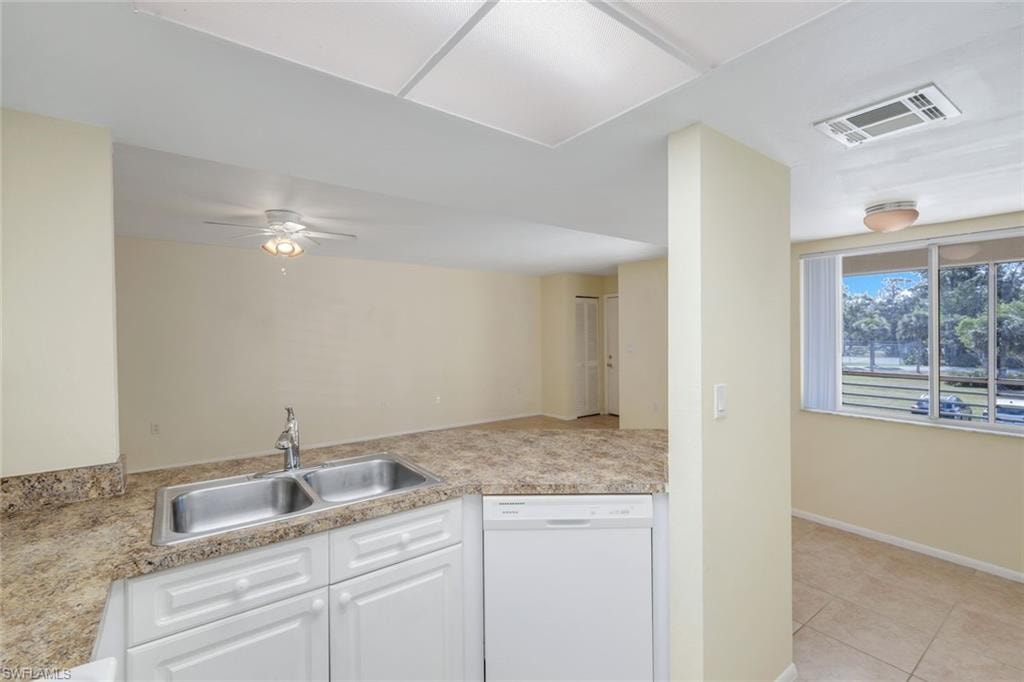 Kitchen featuring visible vents, white cabinets, dishwasher, a sink, and light countertops