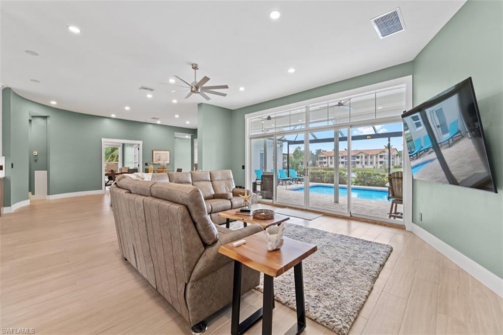 Recessed lighting, ceiling fan, wood-finish flooring, sliding glass doors, and a screened lanai with a pool