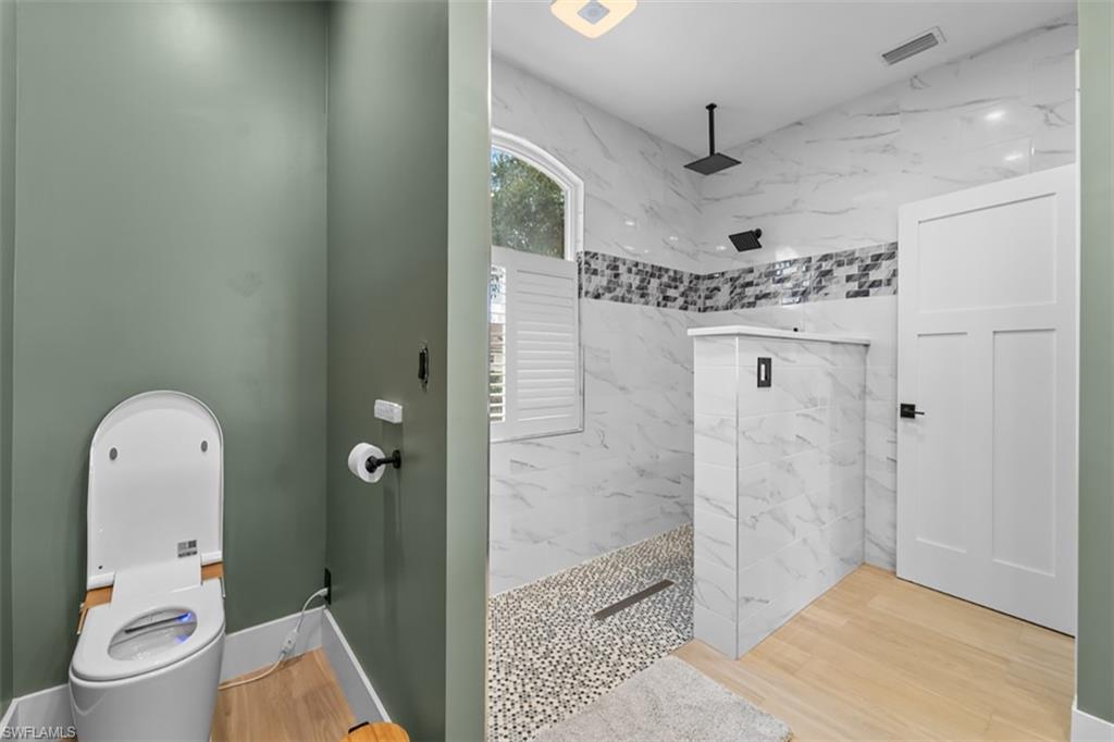 2nd BEDRM Recessed lighting, ceiling fan, wood-finish flooring, white window trim, and a shower with a sliding glass door