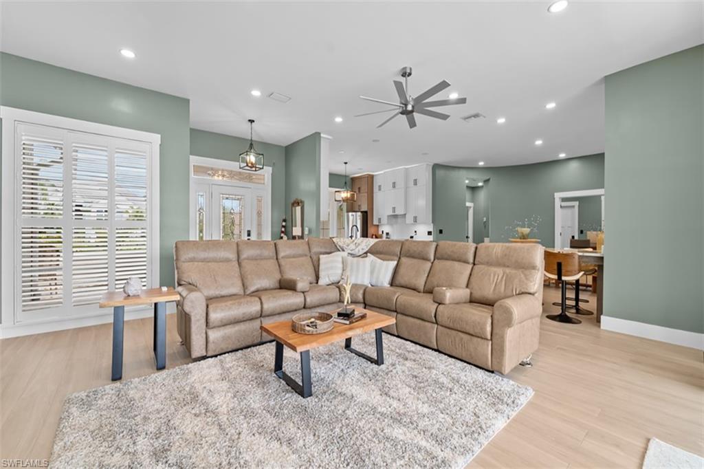 Expansive living area featuring light wood-finish flooring, recessed lighting, and a contemporary ceiling fan