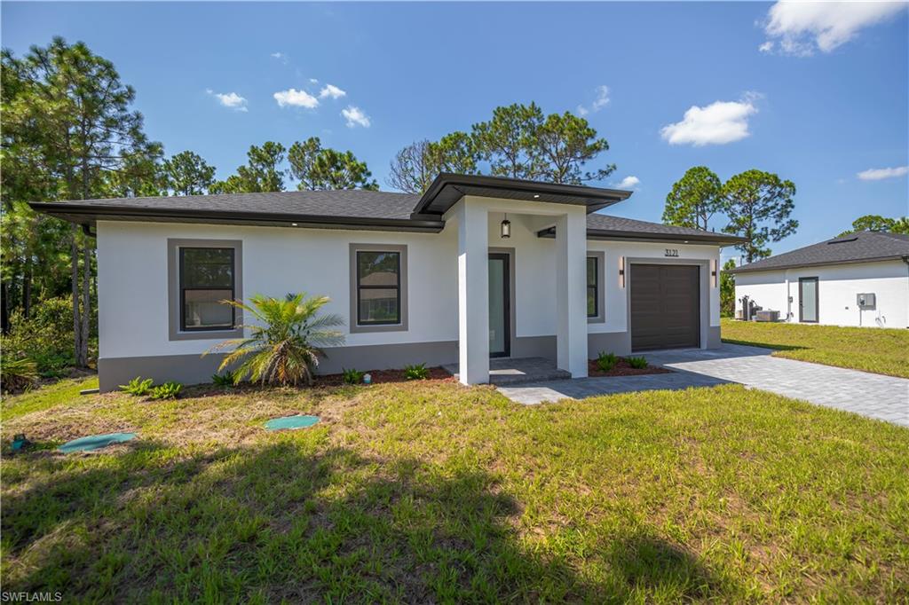 Contemporary exterior with a covered entry, stucco finish, paver driveway, and an integrated garage