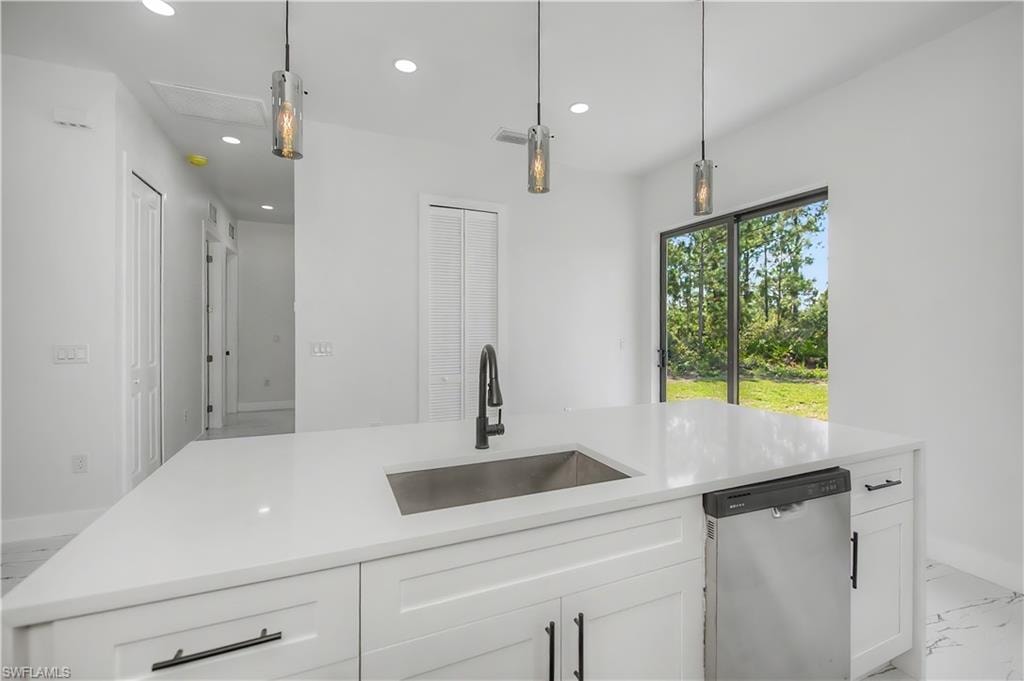 Kitchen island with a stainless steel sink, black gooseneck faucet, and quartz countertop