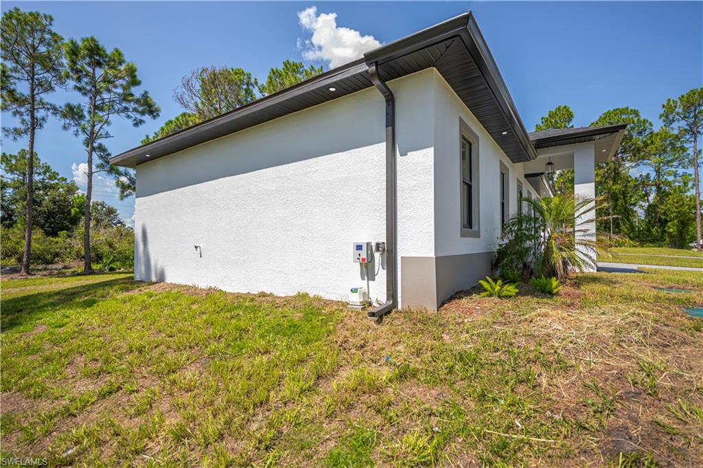 Stucco exterior with a two-tone finish, dark-framed windows, and a covered entryway