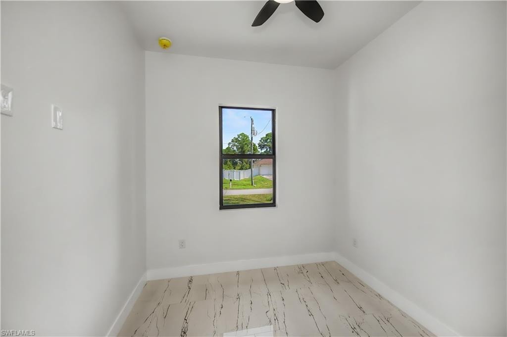 White walls with tile flooring, a single window, and a ceiling fan