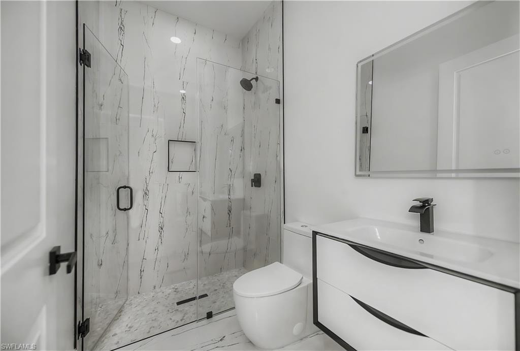 Walk-in shower with clear glass enclosure and black hardware