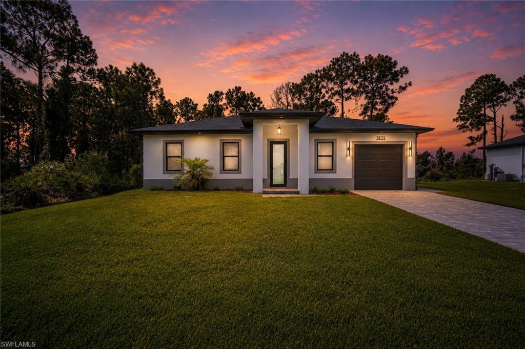 Modern exterior with a neutral stucco finish and a dark gray garage door