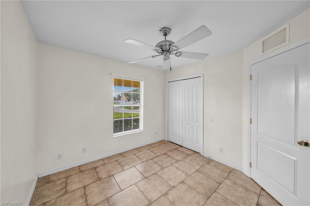 Tiled flooring, ceiling fan with integrated lighting, bi-fold closet doors, and single window