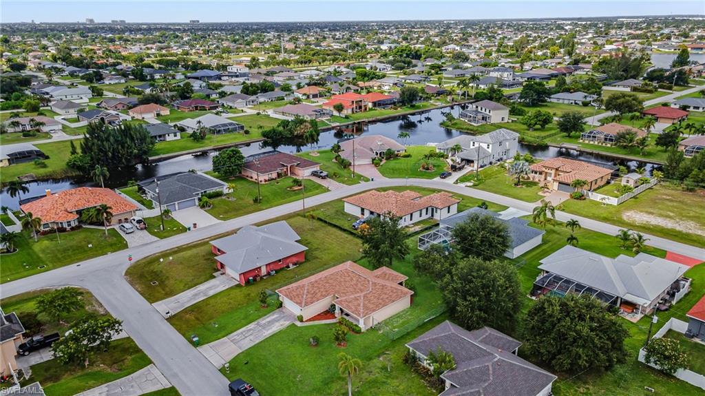 Residential development featuring canals, manicured lawns, and mature trees