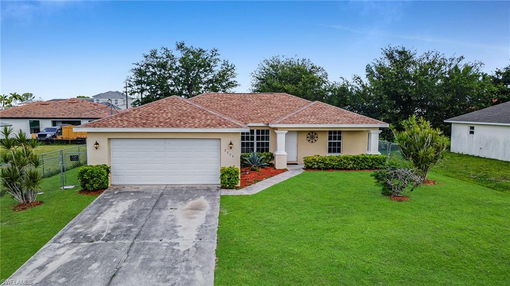 Single-story exterior with a two-car garage, front yard landscaping, and a covered entry
