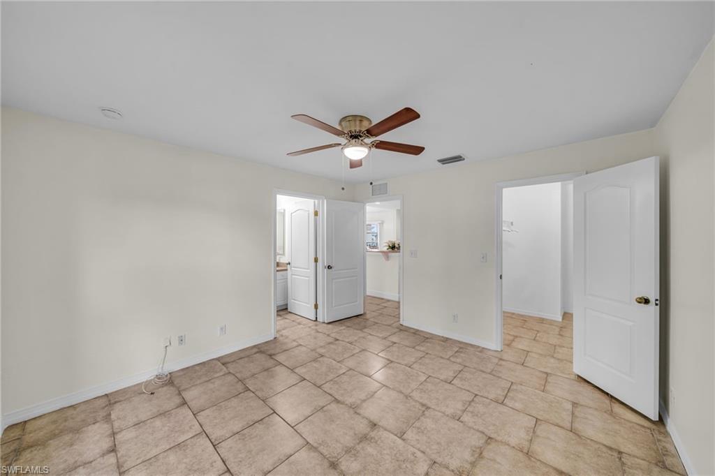 Spacious room featuring tile flooring, a ceiling fan with integrated lighting, and neutral wall tones