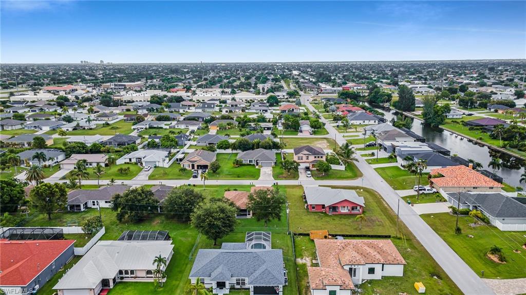 Residential area featuring single-story homes, established landscaping, and a canal system