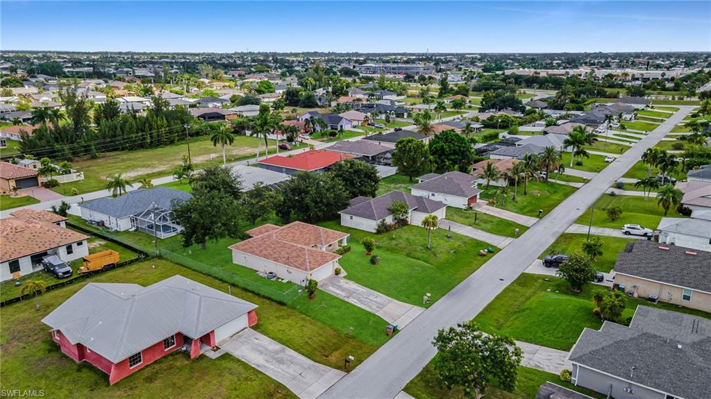 Residential street with established homes, green lawns, and mature trees