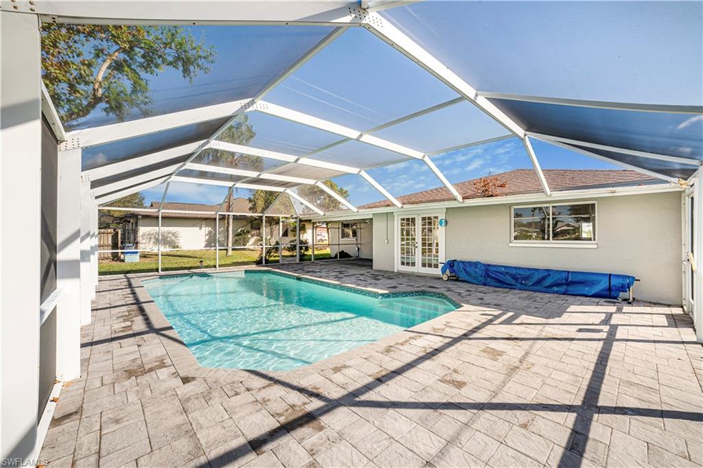 View of pool featuring a lanai, a patio, and french doors