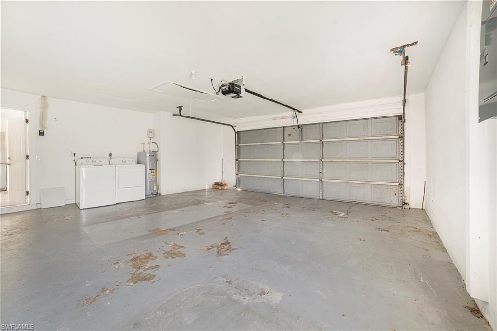 Garage with a garage door opener, washing machine and dryer, and water heater
