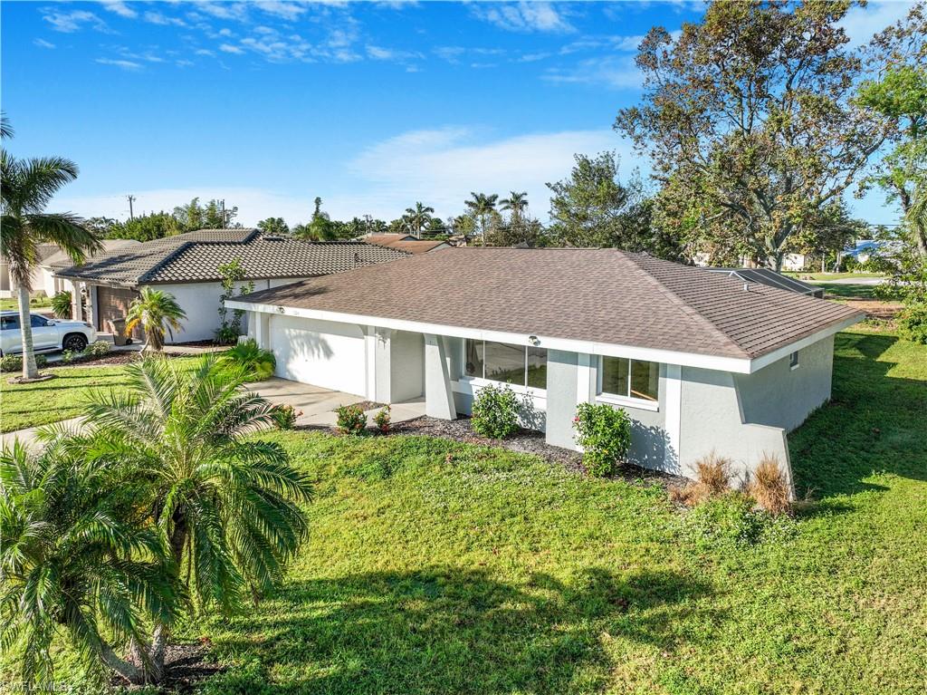 Ranch-style house featuring a garage and a front yard