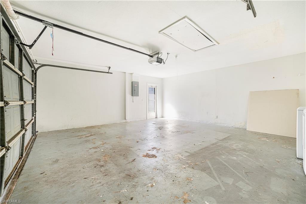 Garage with electric panel and a garage door opener