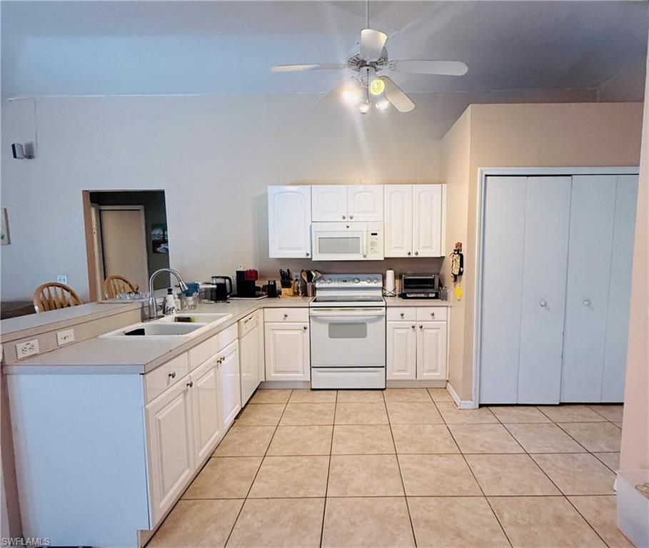 L-shaped kitchen with white cabinetry and light-toned countertops