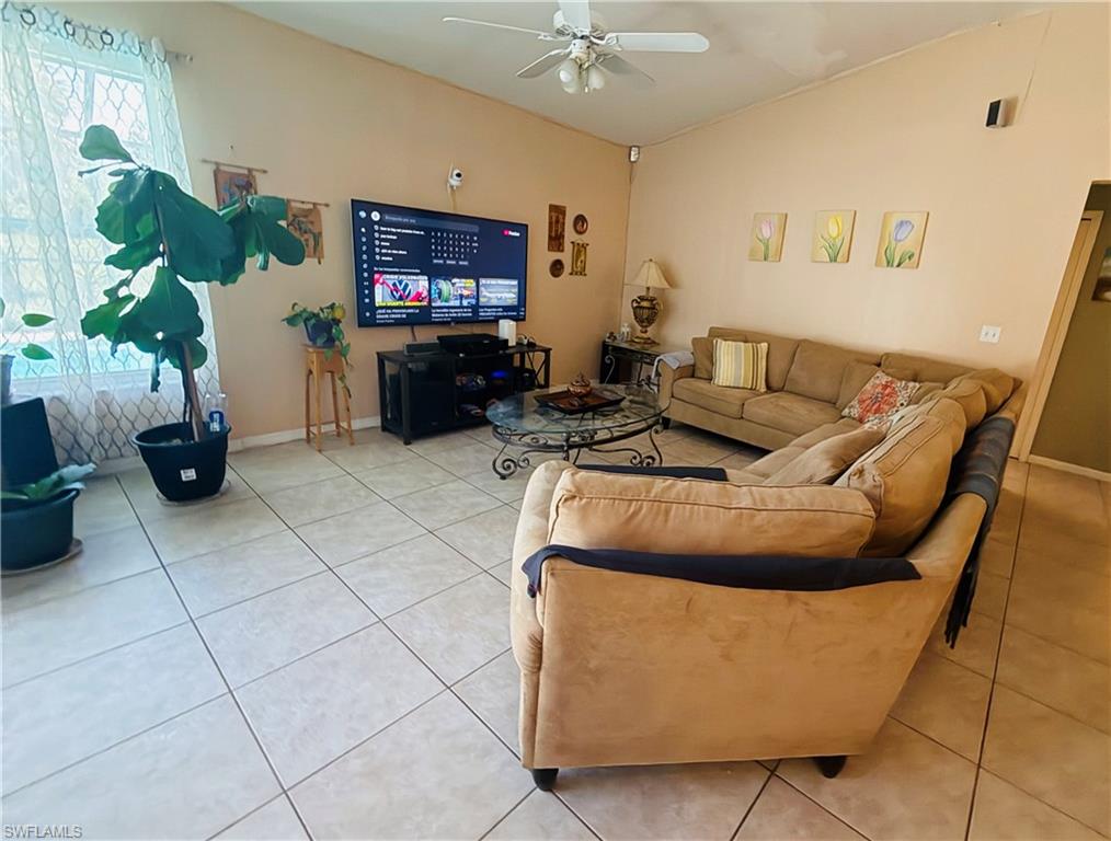 Vaulted ceiling, ceramic tile flooring, ceiling fan, and recessed window