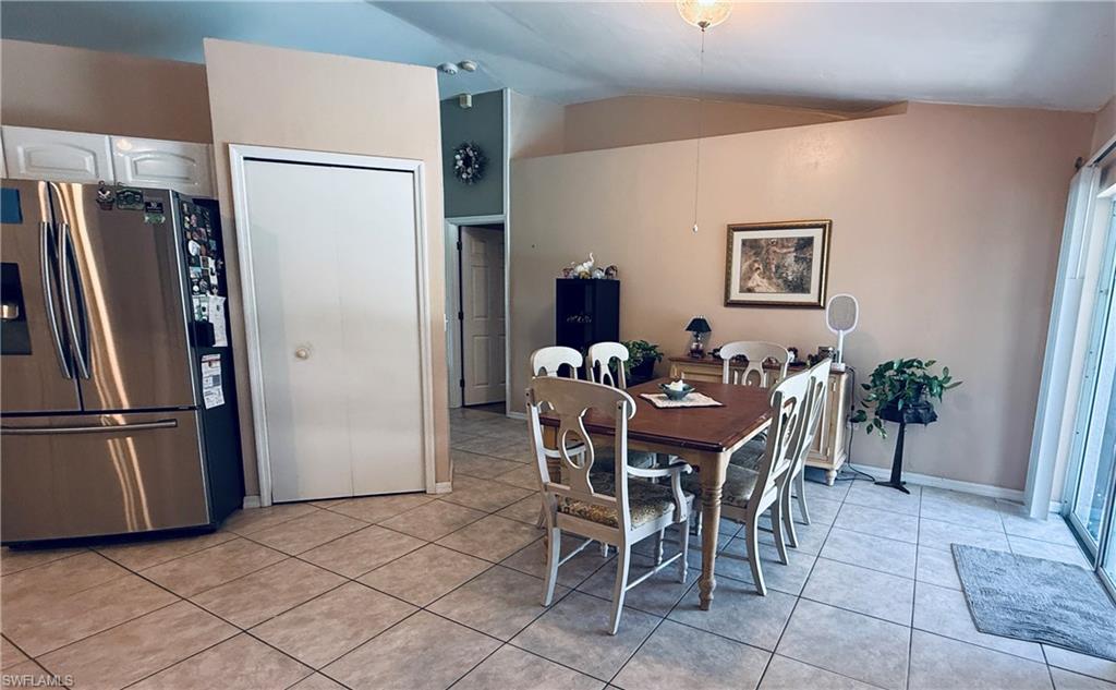 Tile flooring throughout, vaulted ceiling, and sliding glass door