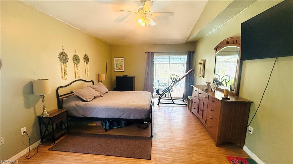 Wood-finish flooring, ceiling fan with integrated lighting, recessed lighting, and sliding glass door
