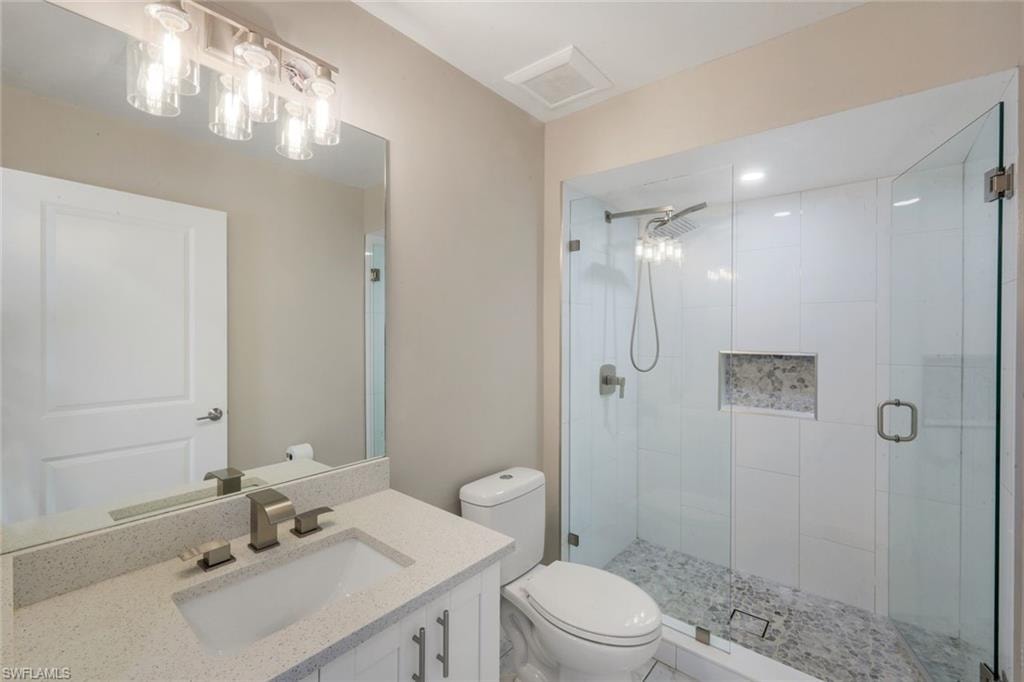 Vanity with light-toned countertop, rectangular undermount sink, and brushed nickel fixtures