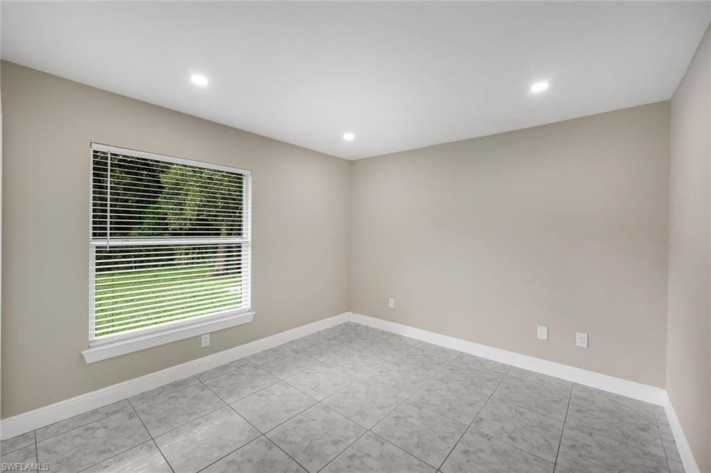 Recessed ceiling lighting, a window with horizontal blinds, tiled flooring, and light-toned wall finishes