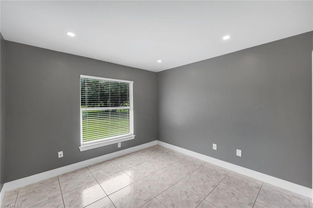 Recessed lighting, tile flooring, window with blinds, white trim, and gray walls