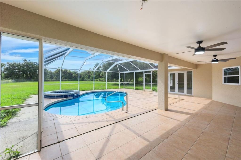 Screened lanai with tiled flooring overlooking resort-style saltwater pool featuring curved design and sun shelf