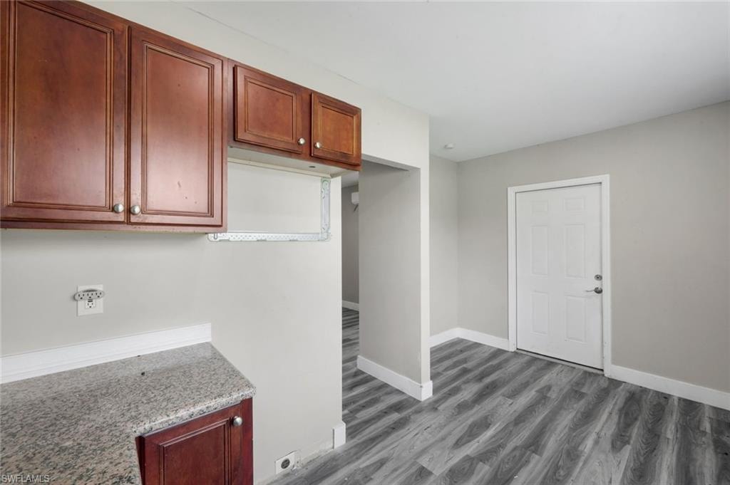 Wood-finish flooring, white baseboards, and neutral wall tones
