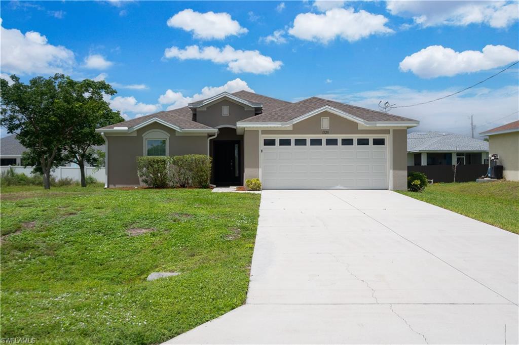 Contemporary stucco exterior with a hip roof, attached two-car garage, and a concrete driveway