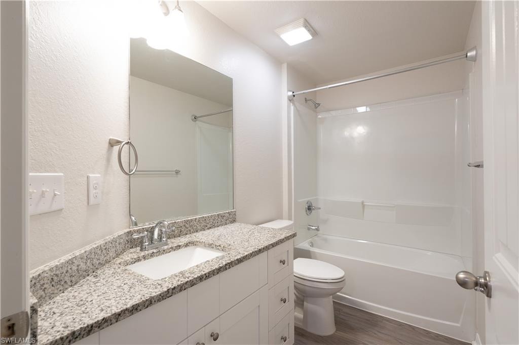 Vanity with granite-style countertop, undermount sink, and chrome fixtures