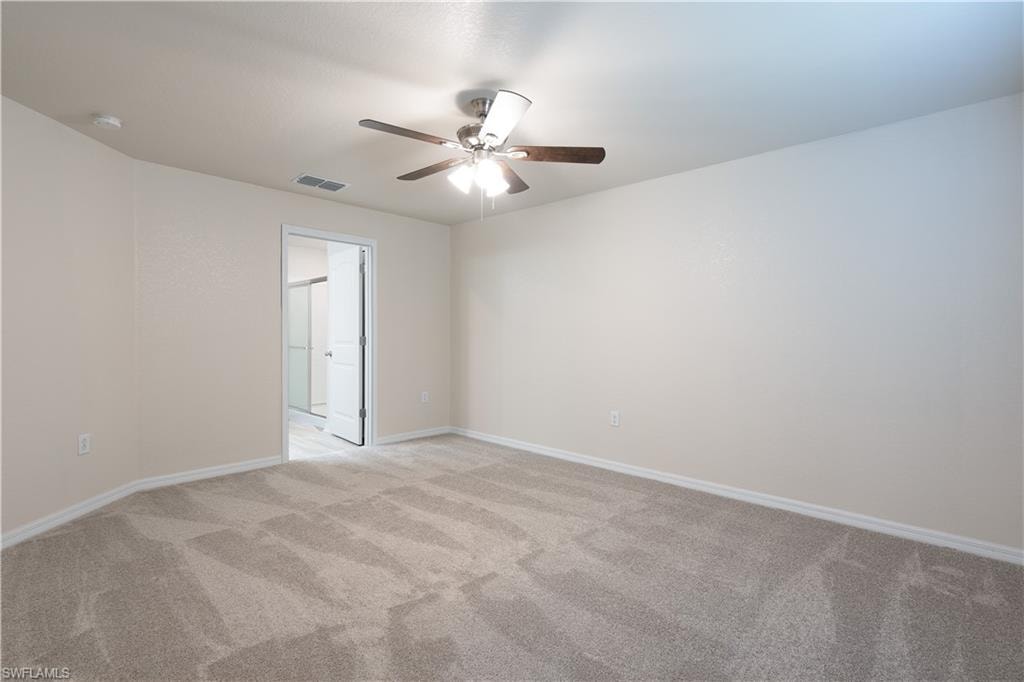 Carpeted room featuring a ceiling fan with integrated lighting
