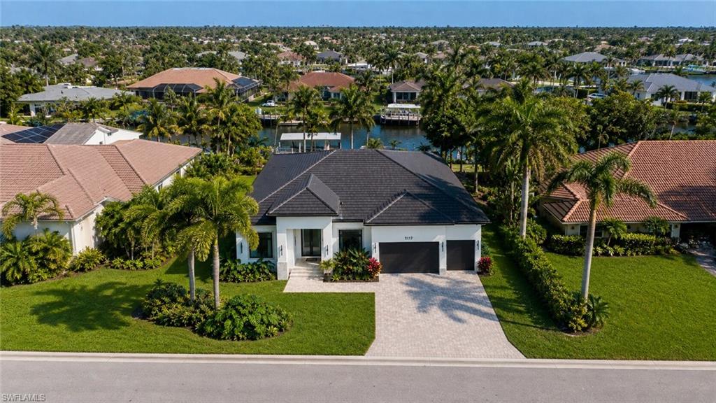(Rendered photo) Single-story residence featuring a dark shingle roof, paved driveway, and a two-car garage