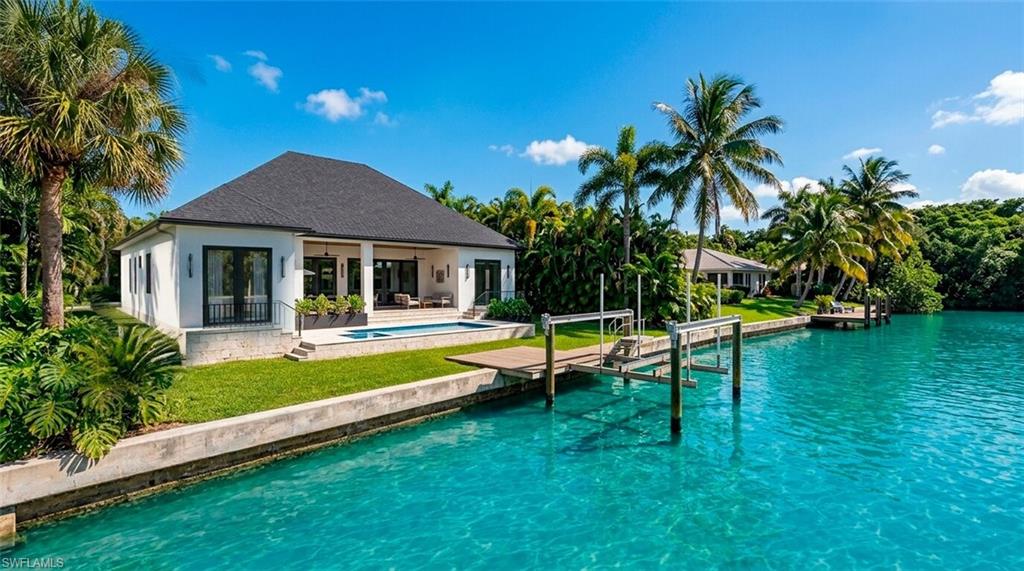 (Rendered photo) Waterfront residence featuring a private dock, sparkling pool, and a covered patio
