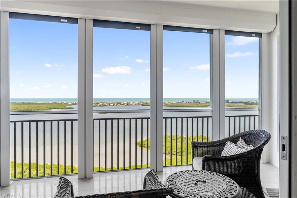 Expansive balcony featuring large windows, a metal railing, and a tiled floor