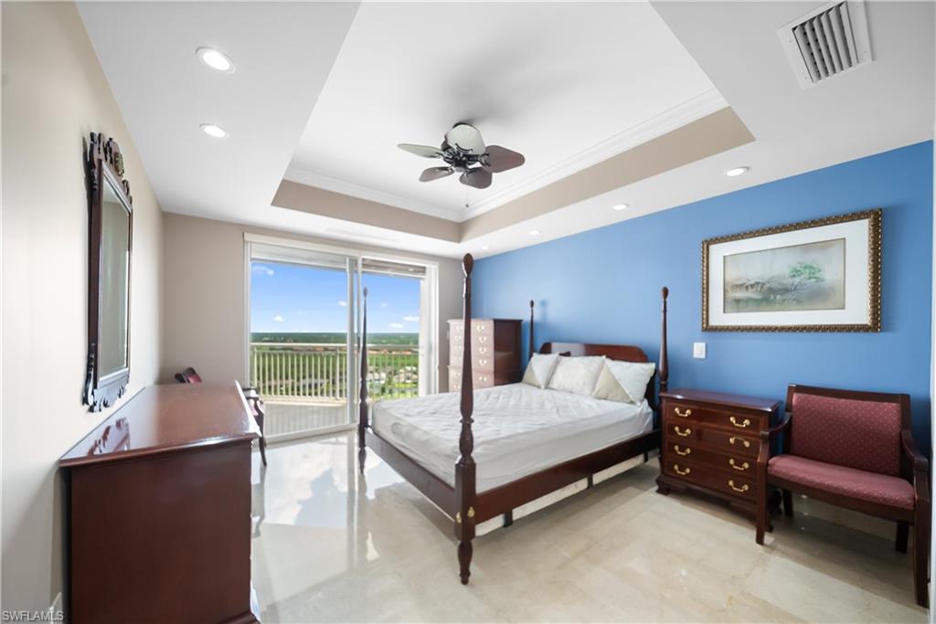 Recessed lighting, ceiling fan, tray ceiling, sliding glass doors, and light-toned flooring